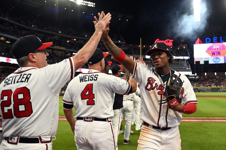 Sep 21, 2019; Cumberland, GA, USA; Atlanta Braves center fielder Ronald Acuna Jr. (13) high fives Atlanta Braves hitting coach Kevin Seitzer (28) after defeating the San Francisco Giants at SunTrust Park. Mandatory Credit: Adam Hagy-USA TODAY Sports