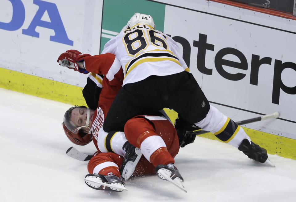 Boston Bruins defenseman Kevan Miller (86) takes down Detroit Red Wings left wing Justin Abdelkader (8) and is called for roughing during the second period of Game 4 of a first-round NHL hockey playoff series in Detroit, Thursday, April 24, 2014. (AP Photo/Carlos Osorio)