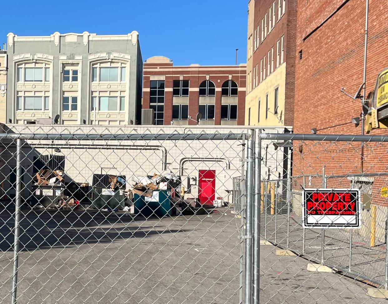 Businesses along Fourth Street in downtown Louisville are unable to access dumpsters they had used in this alley because the lot's owner has fenced it off.