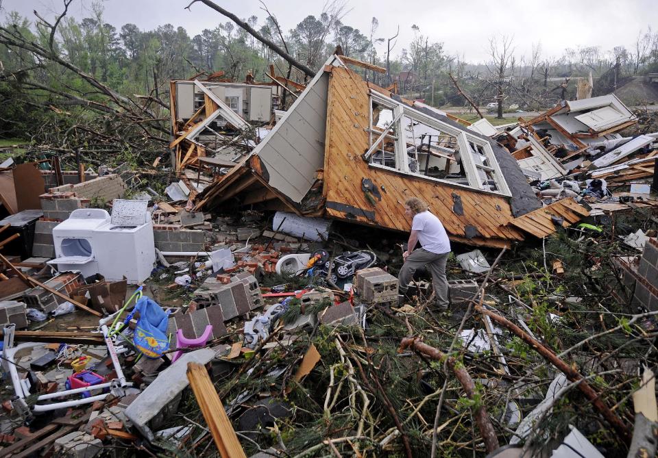 Kevin Barnes searches the remains of his home on Clayton Avenue in Tupelo, Miss., Tuesday, April 29, 2014. A dangerous storm system that spawned a chain of deadly tornadoes over three days flattened homes and businesses, forced frightened residents in more than half a dozen states to take cover and left tens of thousands in the dark Tuesday. (AP Photo/Thomas Graning)