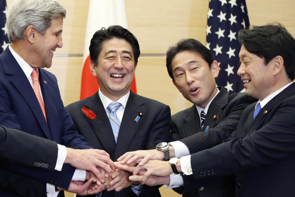FILE - Japanese Prime Minister Shinzo Abe, center, laughs with U.S. Secretary of State John Kerry, left, Japanese Foreign Minister Fumio Kishida, second from right, and Japanese Defense Minister Itsunori Onodera as they put their hands together during their meeting at the prime minister's official residence in Tokyo on Oct. 3, 2013. Assassinated former Prime Minister Shinzo Abe was perhaps the most divisive leader in recent Japanese history. He was also the longest serving and, by many estimations, the most influential. (AP Photo/Koji Sasahara, Pool, File)