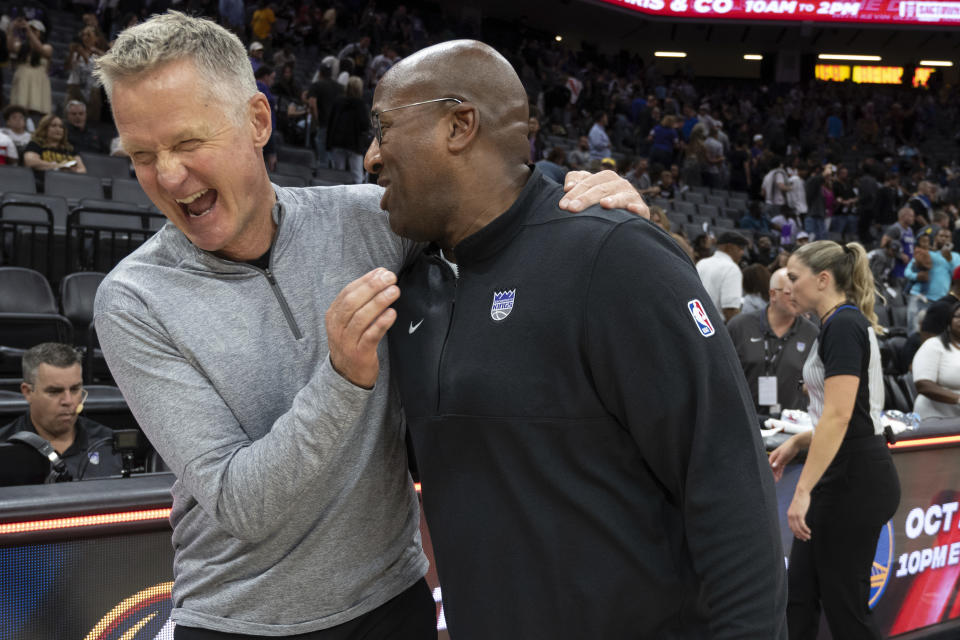 Golden State Warriors head coach Steve Kerr embraces Sacramento Kings head coach Mike Brown following a preseason NBA basketball game in Sacramento, Calif., Sunday, Oct. 15, 2023. The Warriors won 121-115. (AP Photo/José Luis Villegas)