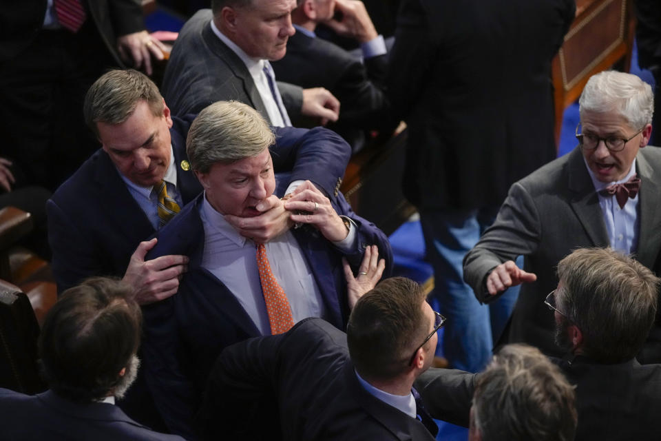 Richard Hudson, legislador republicano de Carolina del Norte, agarra a su compañero Mike Rogers, de Alamaba, mientras hablan con Matt Gaetz, de Florida y otros legisladores durante el cuarto día de votaciones para elegir al presidente de la Cámara de Representantes y formar el 118vo Congreso, en Washington, el 6 de enero de 2023. (AP Foto/Andrew Harnik)