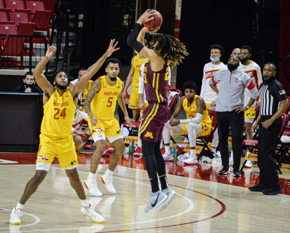 Minnesota forward Brandon Johnson, right, shoots against Maryland forward Donta Scott during the first half of an NCAA college basketball game, Sunday, Feb. 14, 2021, in College Park, Md. (Kevin Richardson/The Baltimore Sun via AP)