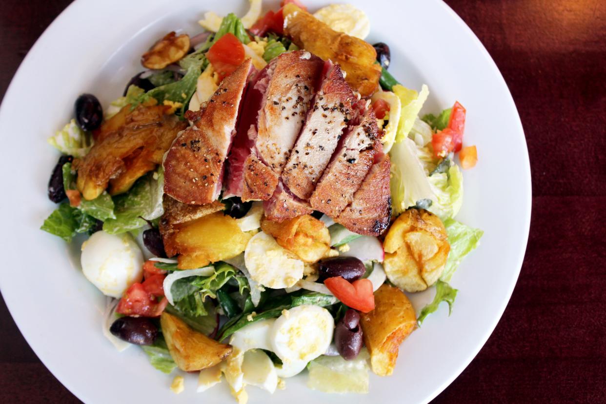 Tuna Niçoise salad at Django features seared ahi tuna, mixed greens, hard-boiled egg, haricots verts, tomato, Niçoise olives, fennel, radish, red onion, crispy potatoes and classic vinaigrette.