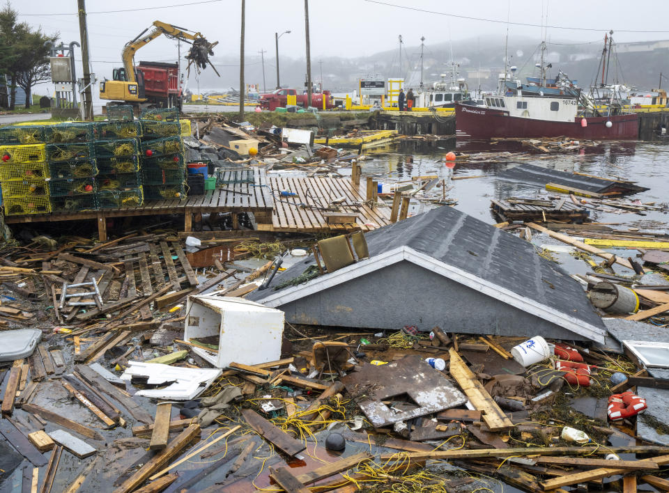 Heavy machinery clears up washed up buildings and rubble in the harbor in Burnt Island, Newfoundland and Labrador on Tuesday Sept. 27, 2022. Fiona left a trail of destruction across much of Atlantic Canada, stretching from Nova Scotia's eastern mainland to Cape Breton, Prince Edward Island and southwestern Newfoundland. (Frank Gunn /The Canadian Press via AP)