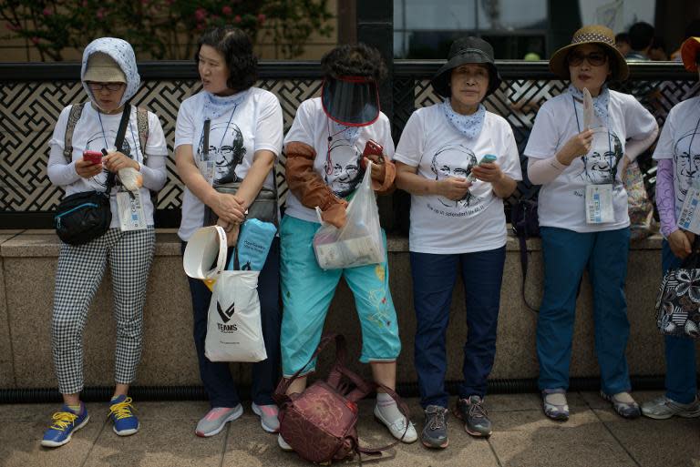 Catholic worshippers wearing papal T-shirts gather for a mass lead by Pope Francis, at Gwanghwamun Square in central Seoul, South Korea, on August 16, 2014