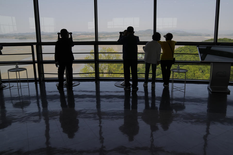 Visitors use binoculars to see the North Korean side from the unification observatory in Paju, South Korea, Thursday, May 12, 2022. North Korea imposed a nationwide lockdown Thursday to control its first acknowledged COVID-19 outbreak after holding for more than two years to a widely doubted claim of a perfect record keeping out the virus that has spread to nearly every place in the world. (AP Photo/Lee Jin-man)