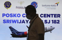 A member of staff walks past at a crisis center set up following a report that a Sriwijaya Air passenger jet has lost contact with air traffic controllers shortly after take off, at Soekarno-Hatta International Airport in Tangerang, Indonesia, Saturday, Jan. 9, 2021. A Boeing 737-500 took off from Jakarta with 56 passengers and six crew members onboard, and lost contact with the control tower a few moments later. (AP Photo/Tatan Syuflana)