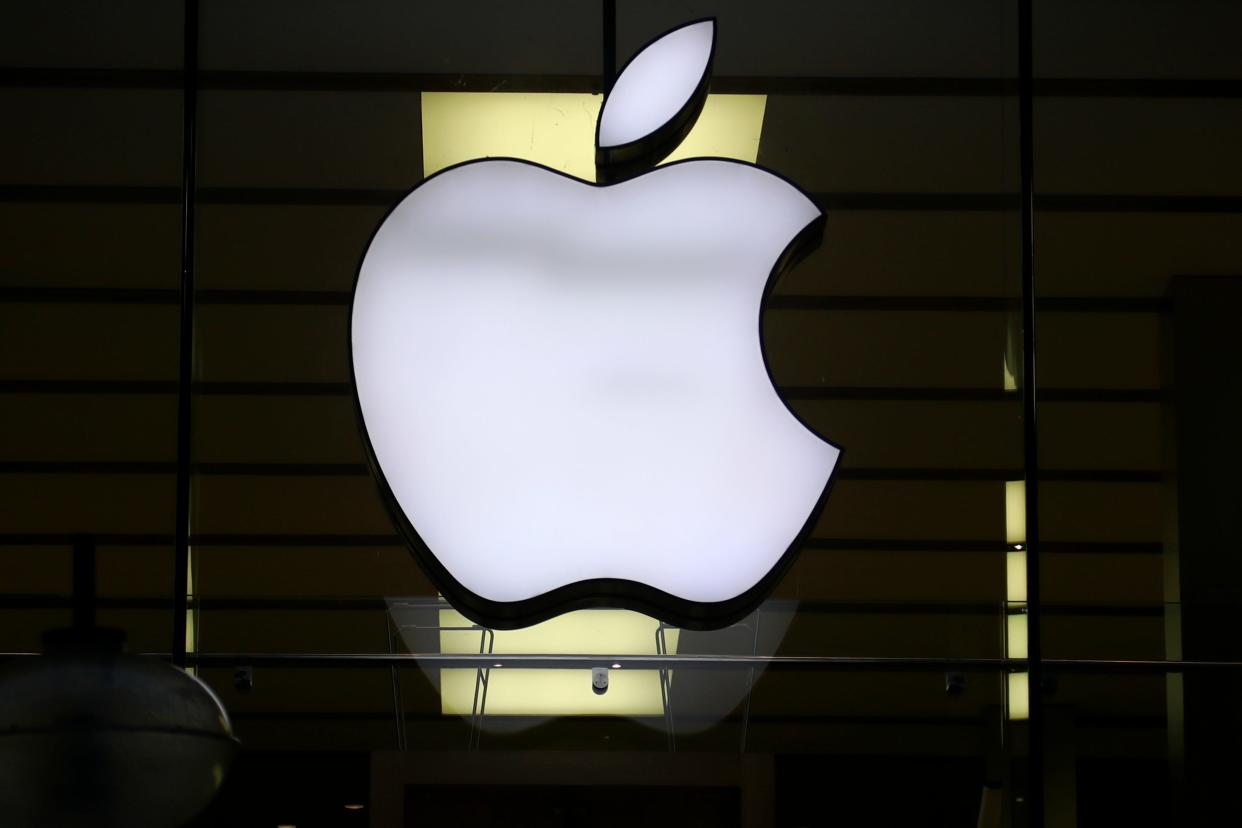 The Apple logo is illuminated at a store in the city center of Munich, Germany on Dec. 16, 2020.