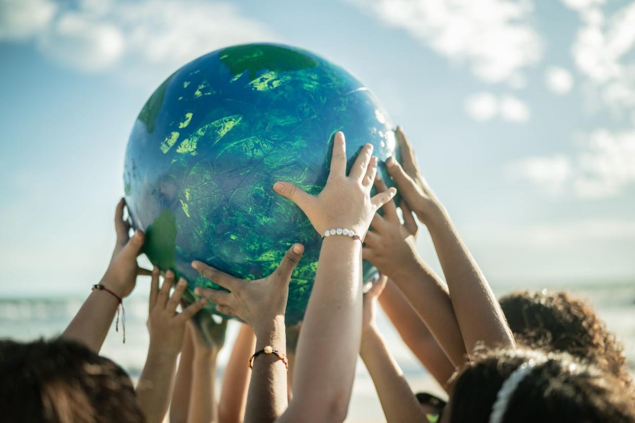 close up of children holding a planet at the beach