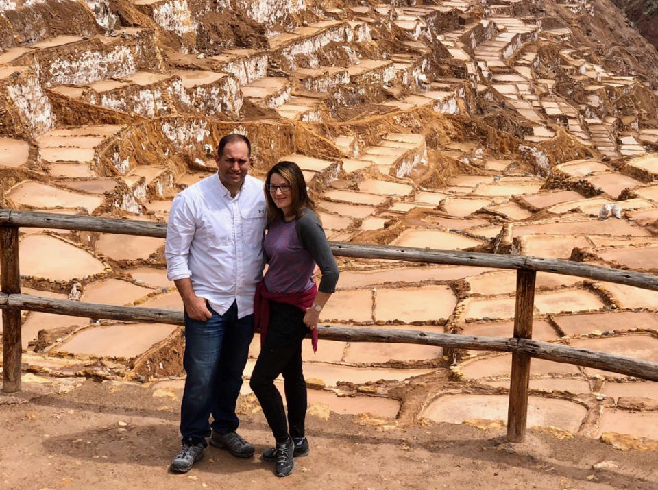 In a photo provided by Linda Scruggs and Mike Rustici, Linda Scruggs and Mike Rustici pose for a photo at salt mines outside Sacred Valley on March 15, 2020, in Peru, just before the Peruvian president announced the country was going under lockdown. The two are trapped in a Lima hotel room and do not know when they will make it back to the U.S. The couple, like thousands around the world, are trapped as nations closed their borders to try to stop the spread of the new coronavirus. (Linda Scruggs and Mike Rustici via AP)