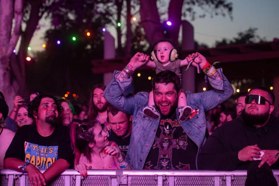 Krisma Pickering, center, of Eugene, Ore., looks up at her 8-month-old son Halen as he sits on Travis Hill’s shoulders while Bring Me the Horizon performs on the Jack Daniel’s Stage on the fourth day at the Aftershock rock festival Sunday, Oct. 9, 2022, at Discovery Park in Sacramento. Sara Nevis/snevis@sacbee.com