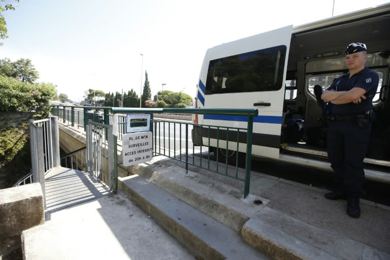 A French police officer stands guard at the entrance to a public beach closed to locals during a visit by the Saudi king in Vallauris Golfe-Juan on July 26, 2015