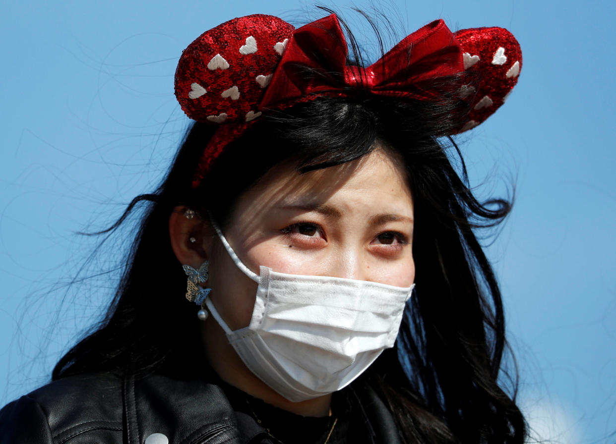 A visitor wearing protective face mask and Minnie Mouse costume, following an outbreak of the coronavirus, is seen outside Tokyo Disneyland in Urayasu, east of Tokyo, Japan February 28, 2020.  REUTERS/Issei Kato