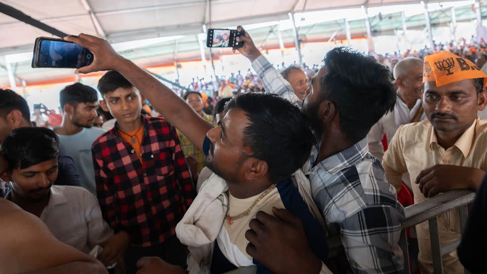Modi supporters take selfies in Aligarh, India, on April 22, 2024. - John Mees/CNN