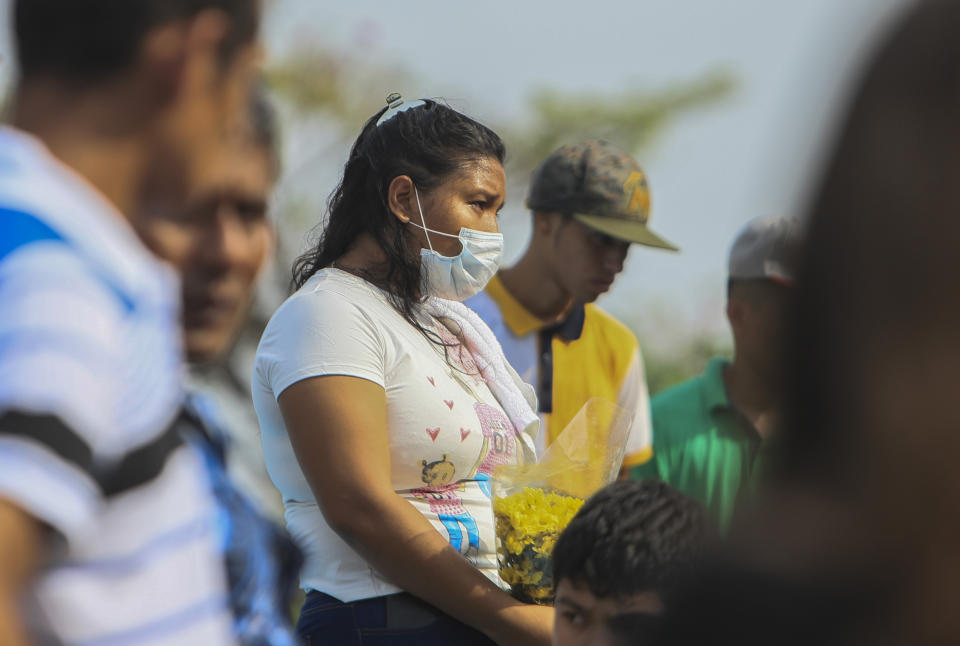 A woman wears a mask against the spread of COVID-19 disease, as she attends a funeral at the Central cemetery of Managua, Nicaragua, Monday, May 11, 2020. President Daniel Ortega's government has stood out for its refusal to impose measures to halt the new coronavirus for more than two months since the disease was first diagnosed in Nicaragua. Now, doctors and family members of apparent victims say, the government has gone from denying the disease's presence in the country to actively trying to conceal its spread. (AP Photo/Alfredo Zuniga)