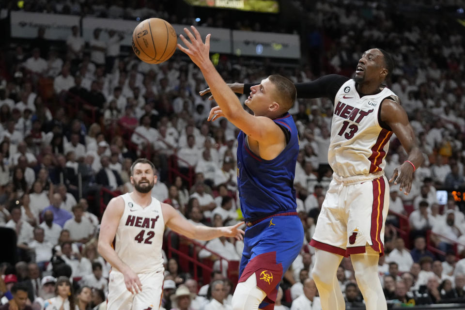 Miami Heat center Bam Adebayo (13) slaps the ball away from Denver Nuggets center Nikola Jokic (15) during the first half of Game 3 of the NBA Finals basketball game, Wednesday, June 7, 2023, in Miami. (AP Photo/Wilfredo Lee)