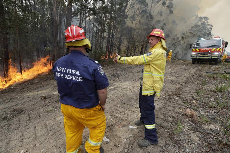 Doug Schutz, right, the Tomerong Rural Fire Service Captain, oversees a controlled burn near Tomerong, Australia, Wednesday, Jan. 8, 2020, set in an effort to contain a larger fire nearby. Schutz began volunteering with the Rural Fire Service in New South Wales some 53 years ago, at the age of 13. That was back in the days when the fire truck was a Land Rover that towed a trailer with a water pump on top. Schutz is part of an army of 72,000 people from across the state who make up the world's largest volunteer fire service. (AP Photo/Rick Rycroft)