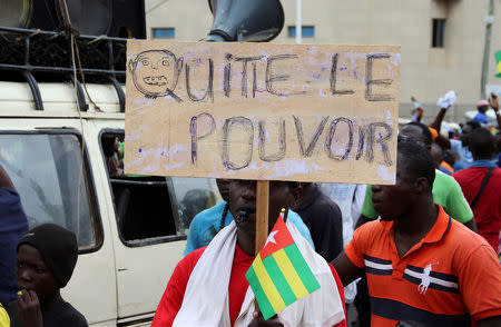 FILE PHOTO: A man holds up a sign which reads, "leave power" during opposition protest to call for the immediate resignation of President Faure Gnassingbe in Lome, Togo, September 7, 2017. REUTERS/Noel Kokou Tadegnon/File Photo