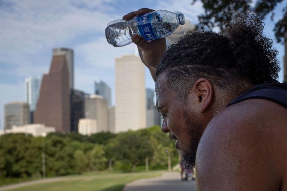 PHOTO: Travis Santiago cools off with water after working out at Eleanor Tinsley Park as temperatures hit 100 degrees Fahrenheit in Houston, July 12, 2023. (Adrees Latif/Reuters)