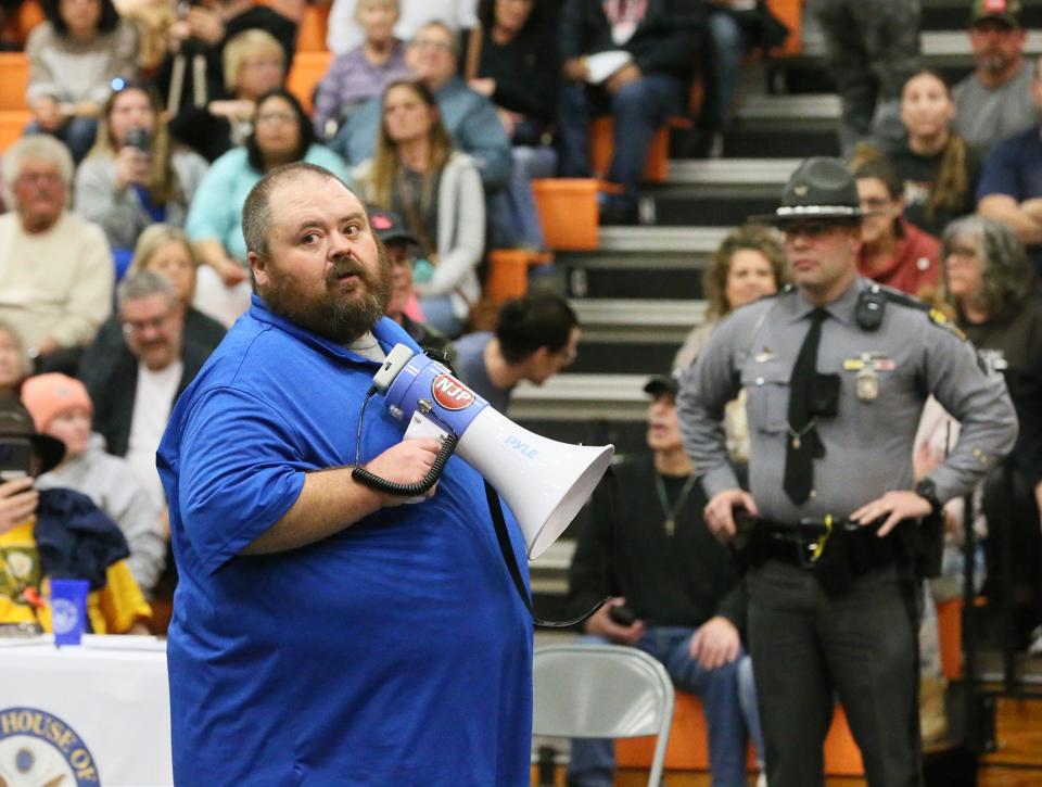 Mayor Trent Conaway uses a bullhorn to address residents gathered at East Palestine High School on Wednesday..