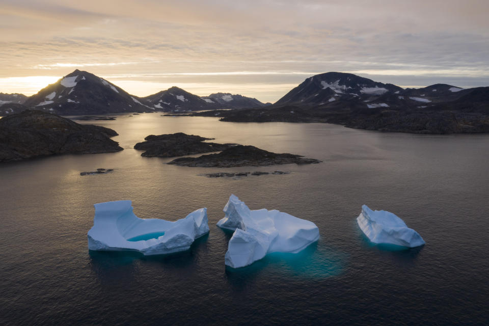 FILE - In this Aug. 16, 2019 file photo, icebergs float away as the sun rises near Kulusuk, Greenland. According to a study released on Thursday, Aug. 20, 2020, Greenland lost a record amount of ice during an extra warm 2019, with the melt massive enough to cover California in more than four feet (1.25 meters) of water. (AP Photo/Felipe Dana, File)