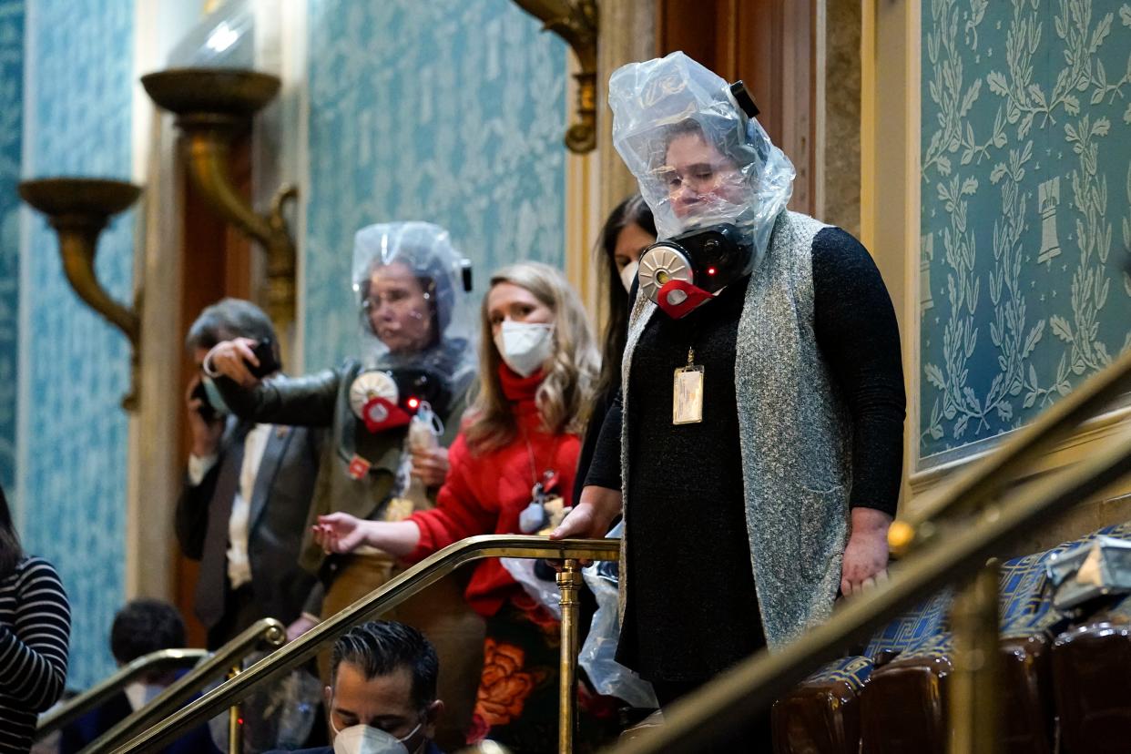 People shelter in the House gallery as protesters try to break into the House Chamber at the U.S. Capitol on Wednesday, Jan. 6, 2021, in Washington.