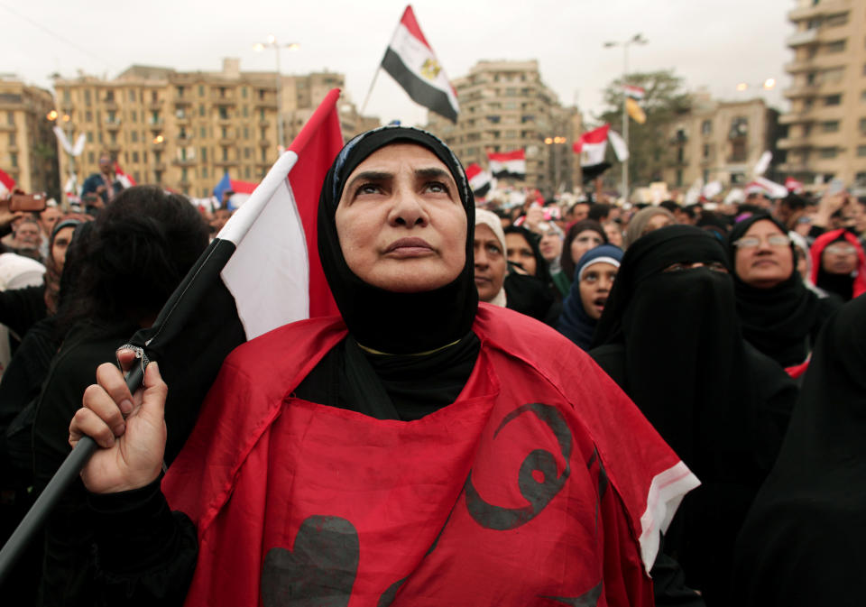 FILE - In this Tuesday, Dec. 4, 2012 file photo, an Egyptian woman holds a national flag as she listens to speakers, not pictured, during a protest calling for the ouster of Islamist President Mohammed Morsi in Tahrir Square in Cairo, Egypt. Women activists say they won a major step forward with Egypt’s new constitution, which enshrined greater rights for women. But months after its passage, they’re worrying whether those rights will be implemented or will turn out to be merely ink on paper. Men hold an overwhelming lock on decision-making and are doing little to bring equality, activists say, and the increasingly repressive political climate is stifling chances for reforms. (AP Photo/Maya Alleruzzo)