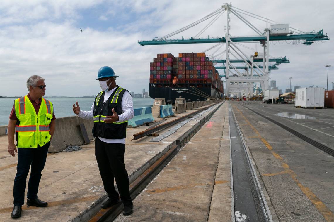 Longshoremen talk as containers are offloaded from a cargo ship at the Port of Miami on Saturday, February 20, 2021.