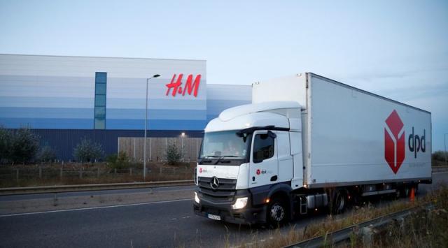 A DPD lorry drives past an H&M warehouse at Magna Park in Milton Keynes