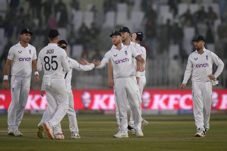 England's Ben Stokes, center, shakes hand with teammates on the end of play of the fourth day of the first test cricket match between Pakistan and England, in Rawalpindi, Pakistan, Sunday, Dec. 4, 2022. (AP Photo/Anjum Naveed)