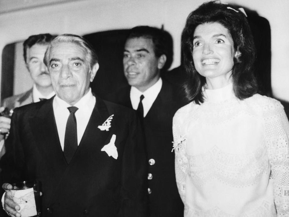 Jackie Kennedy and Aristotle Onassis smile as they are photographed.