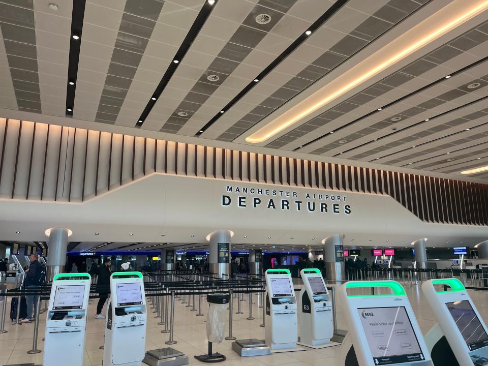 White walls and ticket kiosks at entrance of Manchester Airport departures area