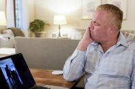 Brian Lilly wipes away tears while watching a video of his son, Brian Lilly Jr., deliver a speech to his rowing team, Thursday, Oct. 13, 2022, in Easton, Conn. Brian Lilly Jr., 19, who committed suicide on Jan. 4, 2021, was a rower at University of California San Diego. The Lillys have filed a wrongful death lawsuit against the university and the rowing coach, Geoff Bond, who is no longer with the school. (AP Photo/Julia Nikhinson)