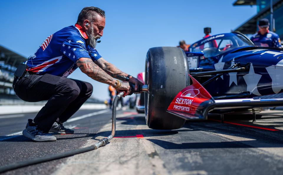Didier Francesia, chief mechanic for A. J. Foyt Enterprises driver Santino Ferrucci (14), changes a front tire Sunday, May 21, 2023, prior to second day of qualifying practice at Indianapolis Motor Speedway in preparation for the 107th running of the Indianapolis 500.