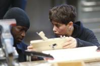 An instructor (R) speaks with a refugee during a workshop organized by the Arrivo Berlin initiative to offer new professional skills, in Berlin, Germany, December 17, 2015. REUTERS/Hannibal Hanschke