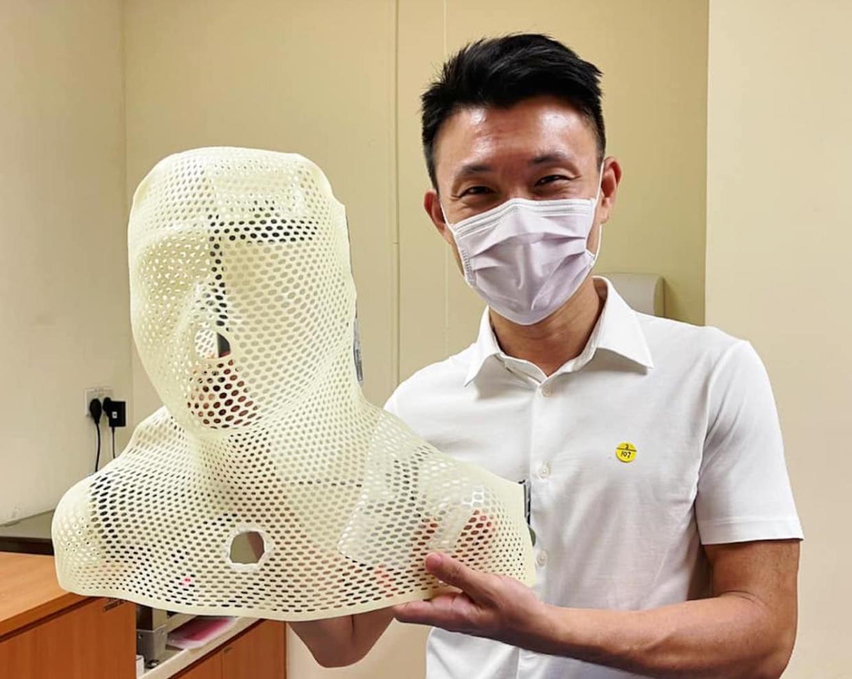 Tampines GRC MP Baey Yam Keng holding a shell which he wears during his radiation therapy sessions to treat his nose cancer. (PHOTO: Baey Yam Keng/Facebook)