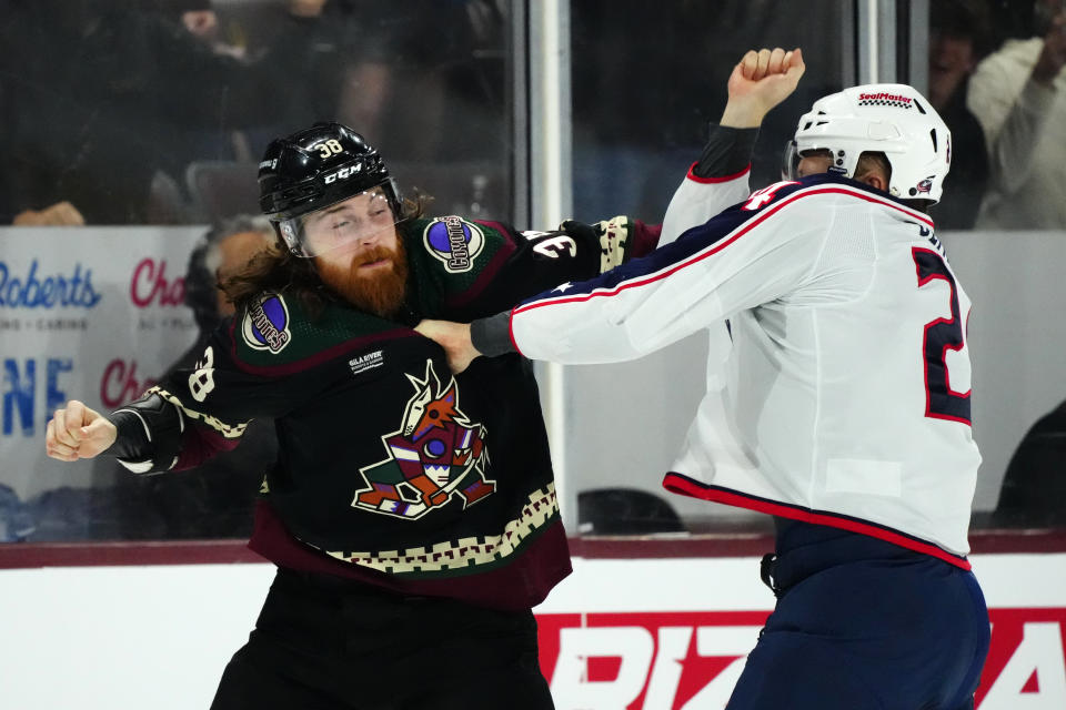 Arizona Coyotes center Liam O'Brien (38) fights with Columbus Blue Jackets right wing Mathieu Olivier, right, during the first period of an NHL hockey game Tuesday, March 26, 2024, in Tempe, Ariz. (AP Photo/Ross D. Franklin)