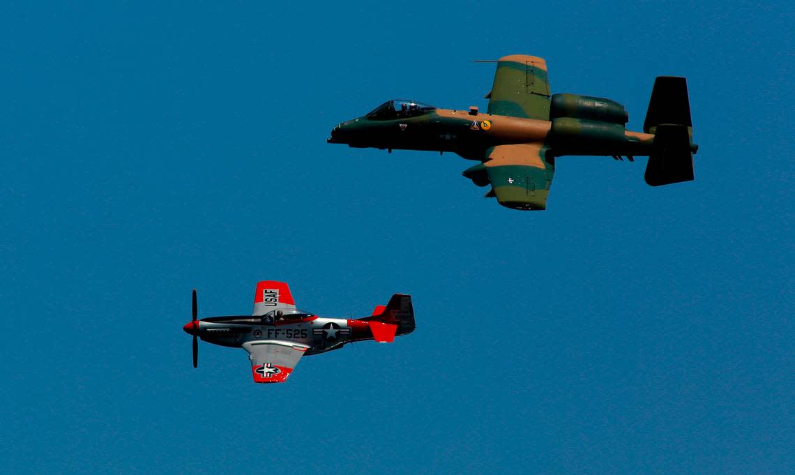 A World War II vintage P-51 Mustang fighter airplane and a modern United States Air Force A-10 jet fighter fly in formation over the Columbia River during the Over the River Air Show at Water Follies