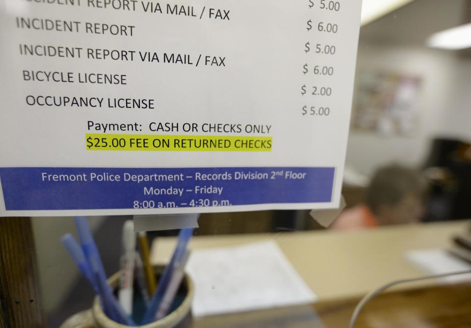 A fee schedule showing an occupancy license costing $5 is seen at the police station in Fremont, Neb., Wednesday, April 9, 2014. On Thursday, April 10, 2014, occupancy licenses will be issued at the Fremont police station as part of the city's ordinance aimed at combatting illegal immigration. (AP Photo/Nati Harnik)