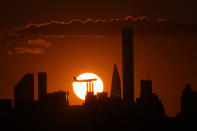 A plane flies at sunset ahead of a match between Caroline Garcia, of France, and Ons Jabeur, of Tunisia, in the semifinals of the U.S. Open tennis championships, Thursday, Sept. 8, 2022, in New York. (AP Photo/Julia Nikhinson)