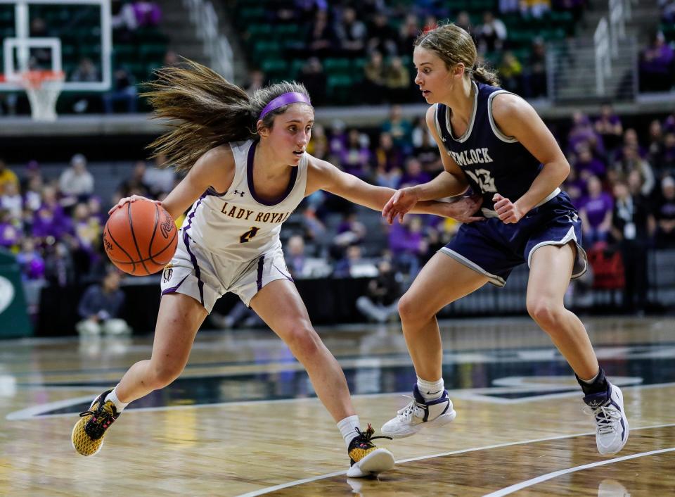 Blissfield guard Avery Collins (4) dribbles against Hemlock guard Regan Finkbeiner (13) during the first half of MHSAA Division 3 girls basketball final at Breslin Center in East Lansing on Saturday, March 18, 2023.
