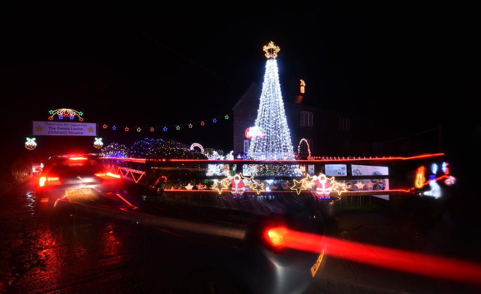 CREWE, ENGLAND - DECEMBER 03: Cars drive past the Weston Christmas light display on December 03, 2020 in Crewe, England. Graham Witter and his family are hosting a drive-through Christmas lights display event at their family home to help raise money for the Donna Louise charity in memory of Graham's sister. (Photo by Nathan Stirk/Getty Images)