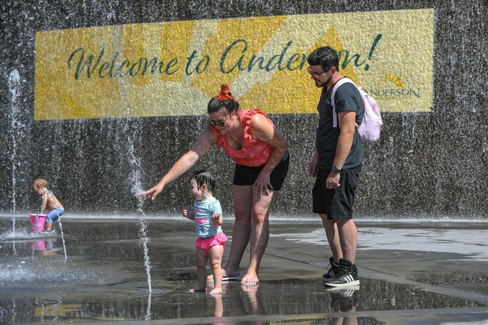 Piper Clark plays with parents Tim and Amber Clark at the Carolina Wren Park Splash Pad in Anderson, S.C. Friday, June 21, 2024.