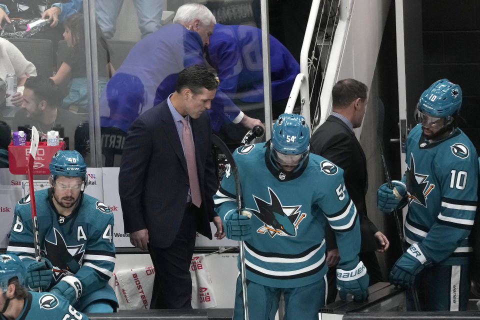 San Jose Sharks head coach David Quinn, middle left, walks behind center Tomas Hertl (48), right wing Givani Smith (54) and left wing Anthony Duclair (10) after the Sharks lost to the Pittsburgh Penguins in an NHL hockey game in San Jose, Calif., Saturday, Nov. 4, 2023. (AP Photo/Jeff Chiu)