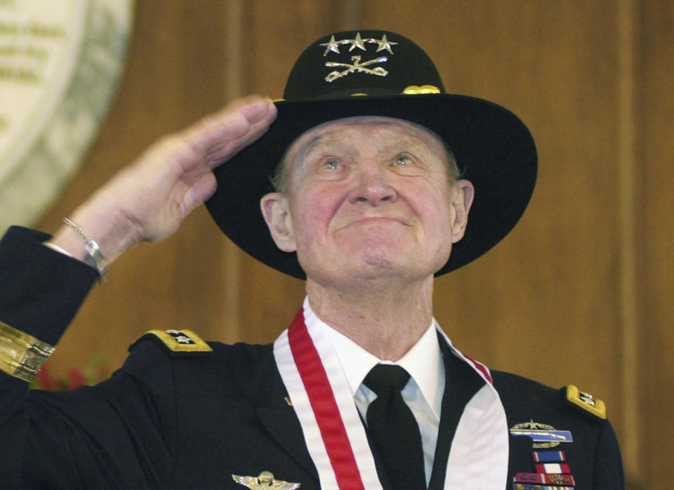 FILE - In this Thursday, Jan. 29, 2004 file photo, retired Lt. Gen. Hal Moore, of Auburn, Ala., salutes the crowd during a standing ovation at the state capitol during the Spirit of Alabama Awards in Montgomery, Ala. Moore, co-author of "We Were Soldiers," was one of several recipients of the award, created by Gov. Bob Riley. On Friday, Feb. 10, 2016, Moore, known for saving most of his men in the first major battle between the U.S. and North Vietnamese armies, died. He was 94. (AP Photo/Jamie Martin)