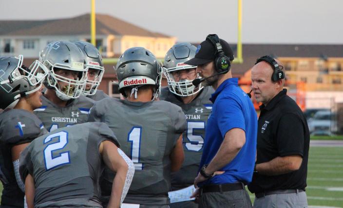 Sioux Falls Christian coach Jared Smith (blue shirt) talks to his offense during a timeout at Bob Young Field.