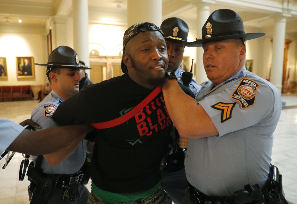 A man is arrested by Georgia state troopers during a protest over election ballot counts in the rotunda of the state capitol building Tuesday, Nov. 13, 2018, in Atlanta. Several protesters, including a state senator, have been arrested during a demonstration at the Georgia state Capitol calling for tallying of uncounted ballots from last week's election. (AP Photo/John Bazemore)