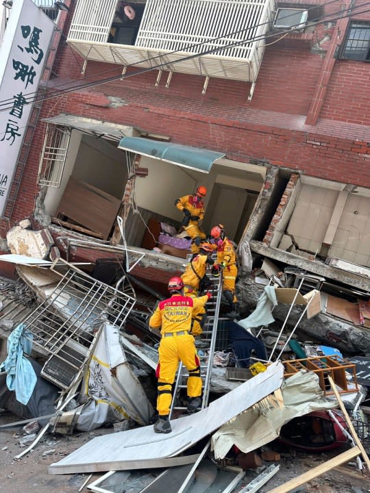 In this photo released by the National Fire Agency, members of a search and rescue team prepare to enter a leaning building in the aftermath of an earthquake in Hualien, eastern Taiwan on Wednesday, April 3, 2024. Taiwan’s strongest earthquake in a quarter century rocked the island during the morning rush Wednesday, damaging buildings and creating a tsunami that washed ashore on southern Japanese islands. (National Fire Agency via AP)